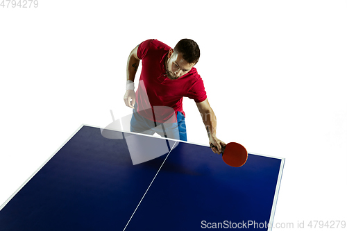 Image of Young man playing table tennis on white studio background