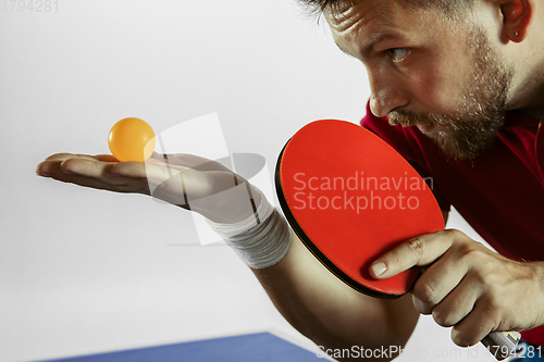 Image of Young man playing table tennis on white studio background