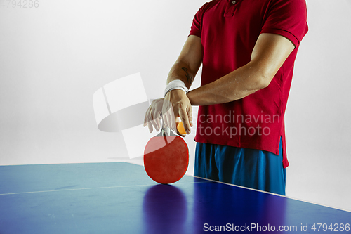 Image of Young man playing table tennis on white studio background