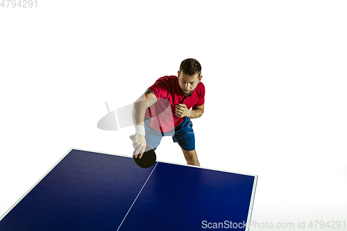 Image of Young man playing table tennis on white studio background