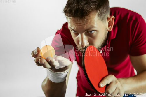 Image of Young man playing table tennis on white studio background
