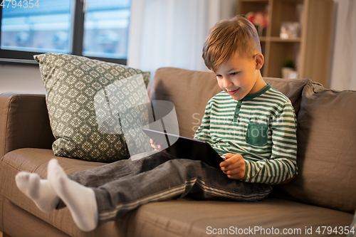 Image of happy little boy with tablet computer at home