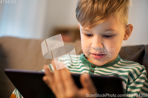 Image of happy little boy with tablet computer at home