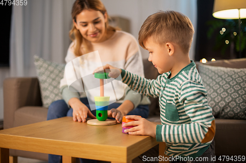 Image of mother and son playing with toy pyramid at home