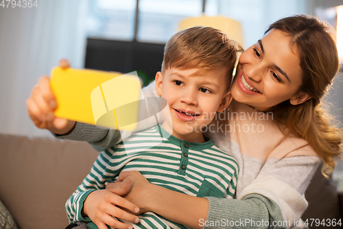 Image of mother and son taking selfie by smartphone at home