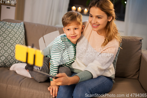 Image of mother and son taking selfie by smartphone at home