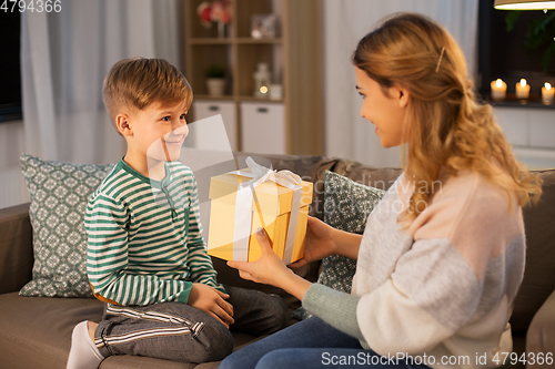 Image of mother giving present to her little son at home