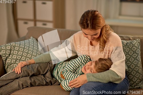 Image of happy mother with sleeping little son at home