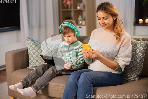 Image of mother and son using gadgets at home