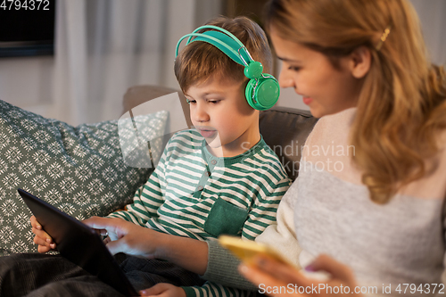 Image of mother and son using gadgets at home