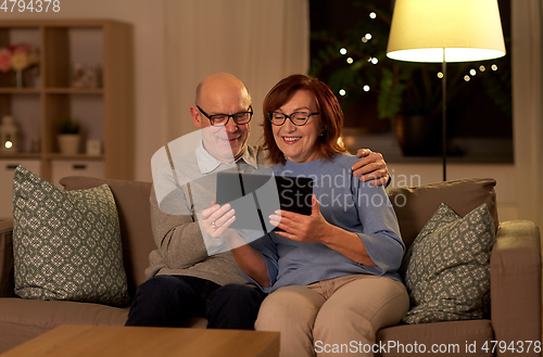 Image of happy senior couple with tablet pc at home