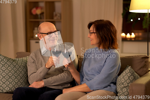 Image of happy senior couple with glasses of red wine