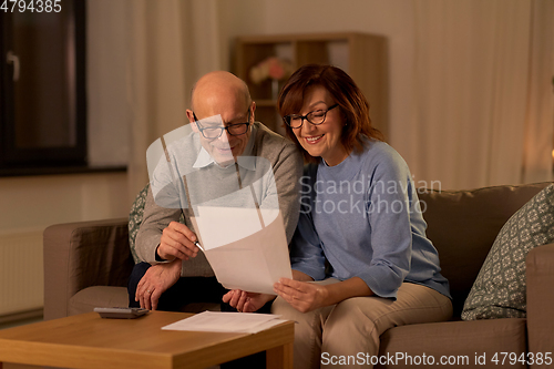 Image of senior couple with papers and calculator at home