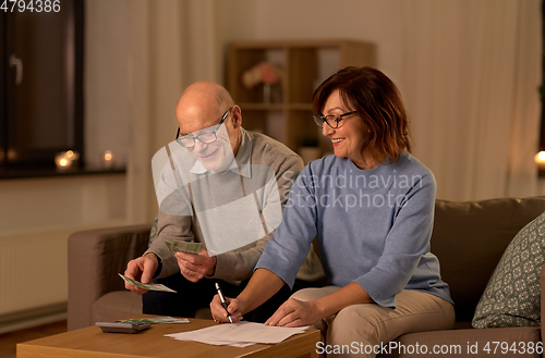 Image of senior couple with bills counting money at home