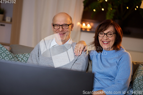 Image of happy senior couple watching tv at home