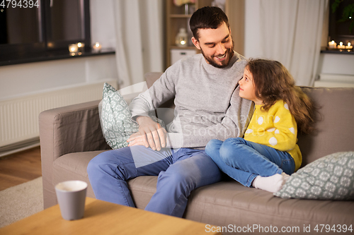 Image of happy father and little daughter at home at night