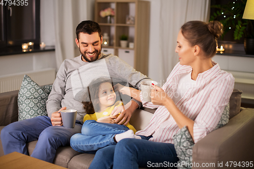 Image of portrait of happy family sitting on sofa at home