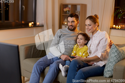 Image of happy family watching tv at home at night