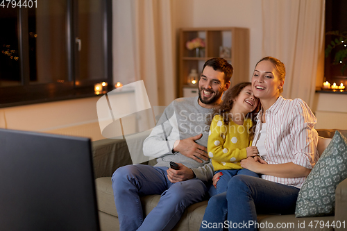 Image of happy family watching tv at home at night