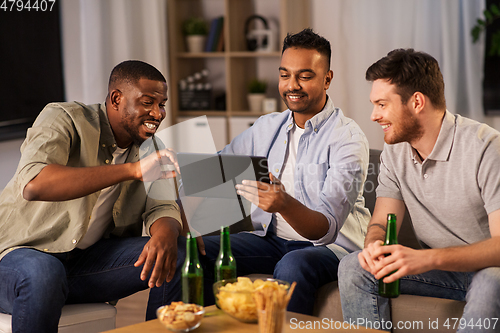 Image of male friends with tablet pc drinking beer at home