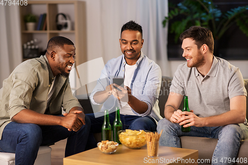 Image of male friends with smartphone drinking beer at home