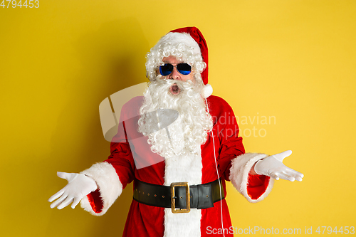 Image of Santa Claus with modern eyeglasses isolated on yellow studio background