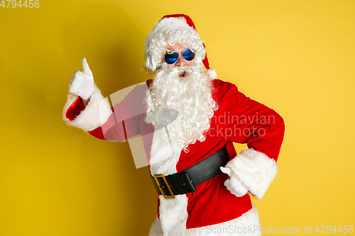 Image of Santa Claus with modern eyeglasses isolated on yellow studio background