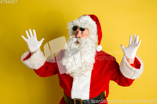 Image of Santa Claus with modern eyeglasses isolated on yellow studio background