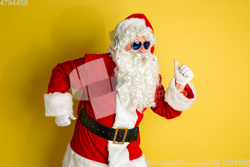 Image of Santa Claus with modern eyeglasses isolated on yellow studio background