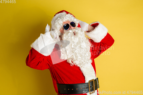 Image of Santa Claus with modern eyeglasses isolated on yellow studio background