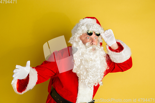 Image of Santa Claus with modern eyeglasses isolated on yellow studio background