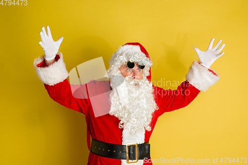 Image of Santa Claus with modern eyeglasses isolated on yellow studio background