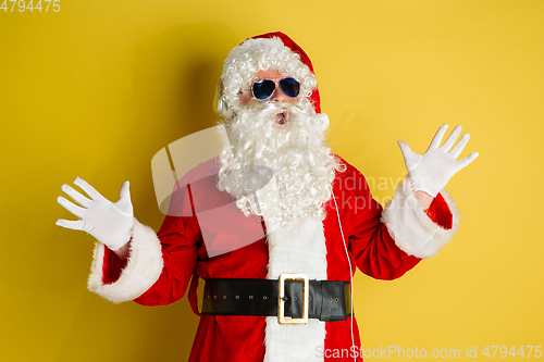 Image of Santa Claus with modern eyeglasses isolated on yellow studio background