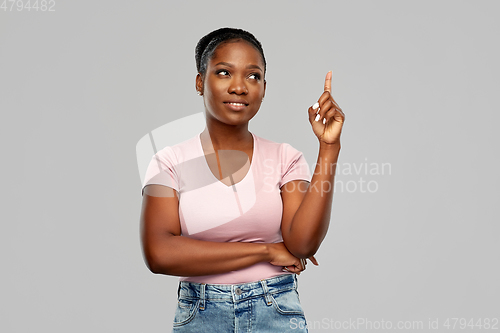 Image of happy african american woman pointing finger up