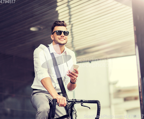 Image of man with bicycle and smartphone on city street