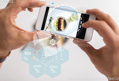 Image of hands with phone and food nutritional value chart