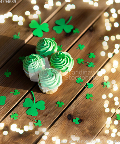 Image of green cupcakes and shamrock on wooden table