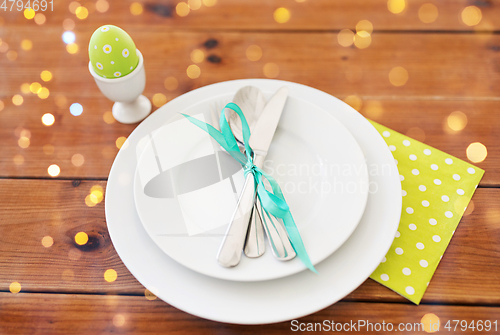 Image of easter egg in cup holder, plates and cutlery