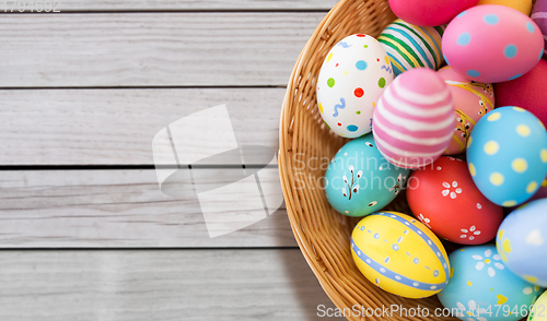 Image of close up of colored easter eggs in wicker basket