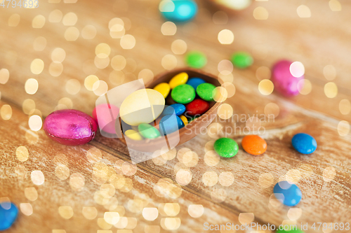 Image of chocolate egg and candy drops on wooden table