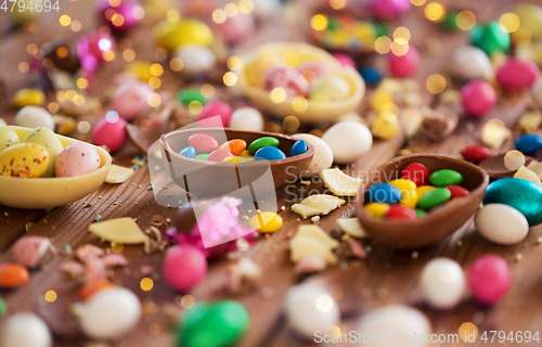 Image of chocolate eggs and candy drops on wooden table