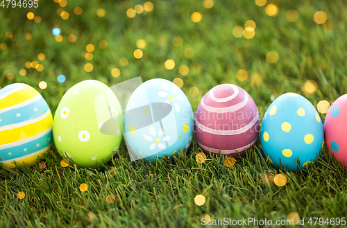 Image of row of colored easter eggs on artificial grass