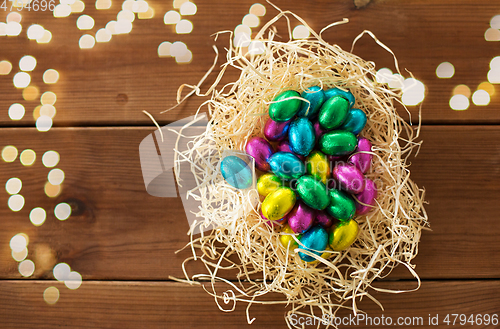 Image of chocolate eggs in foil wrappers in straw nest