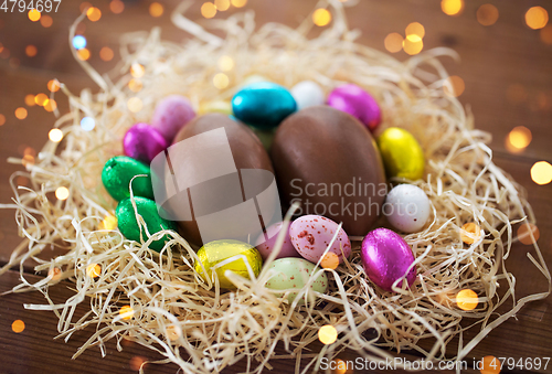 Image of chocolate eggs in foil wrappers in straw nest