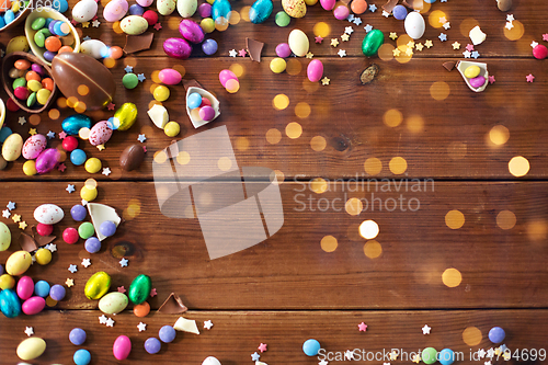 Image of chocolate eggs and candy drops on wooden table