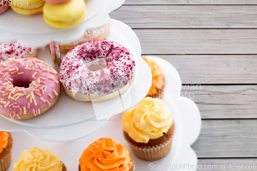 Image of close up of glazed donuts and cupcakes on stand