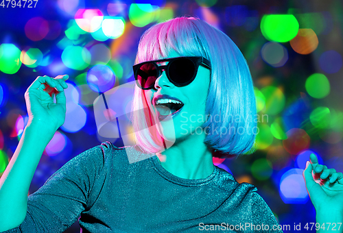 Image of happy woman in pink wig and sunglasses dancing