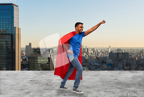 Image of indian man in superhero cape makes winning gesture