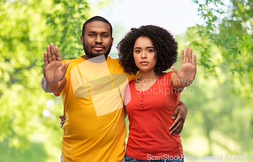 Image of african american couple showing stop gesture