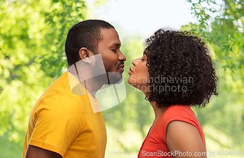 Image of happy african american couple reaching for kiss